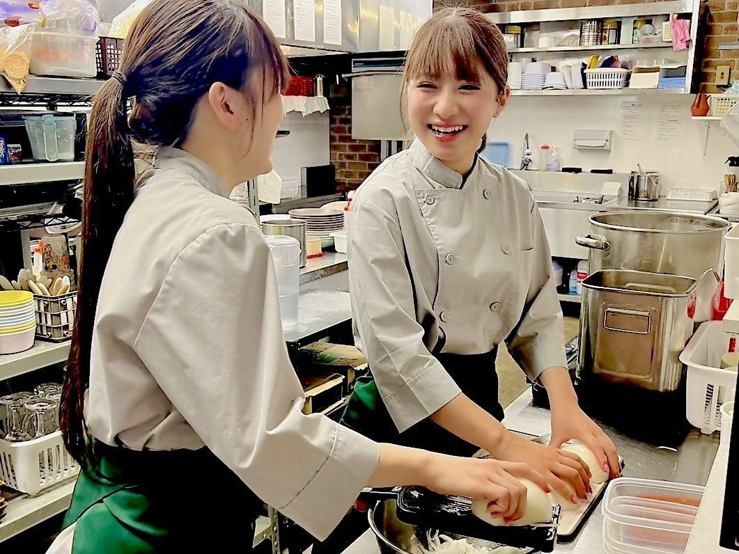 厨房で笑顔で調理するスタッフ
