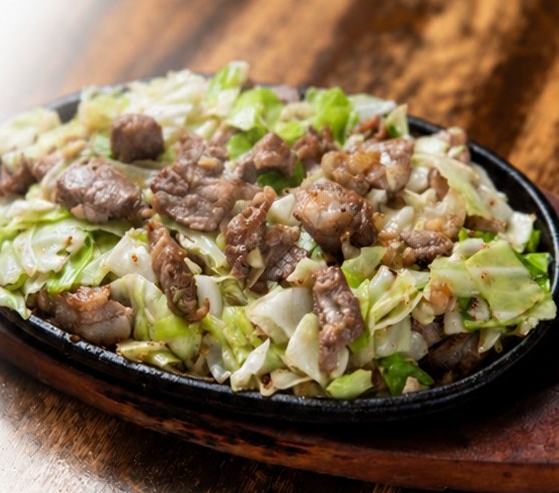 鉄板の上で焼かれた肉とキャベツの料理