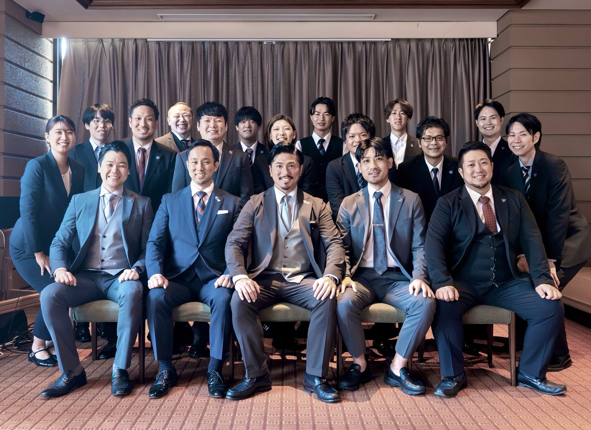 スーツ姿で並ぶZIONEの仲間たちの集合写真