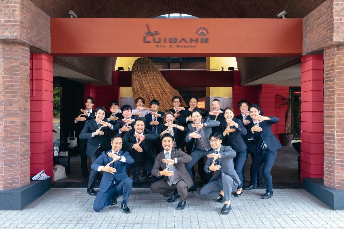 店舗の前でポーズをとるZIONEの仲間たち
